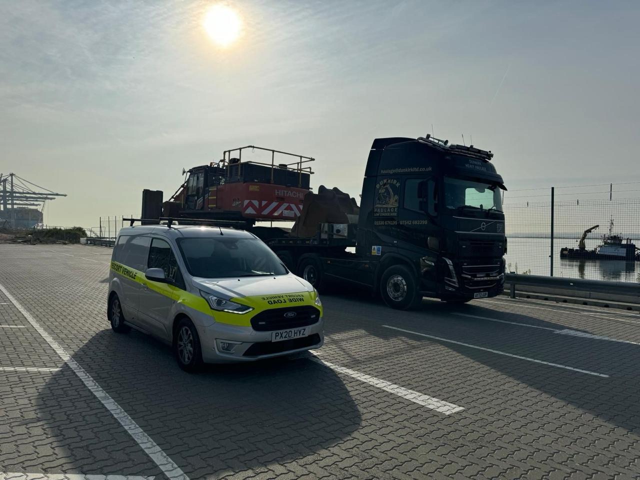 Escort van supporting machinery transport at a port